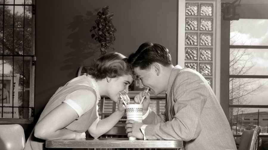 man and woman sharing with one serve milkshake