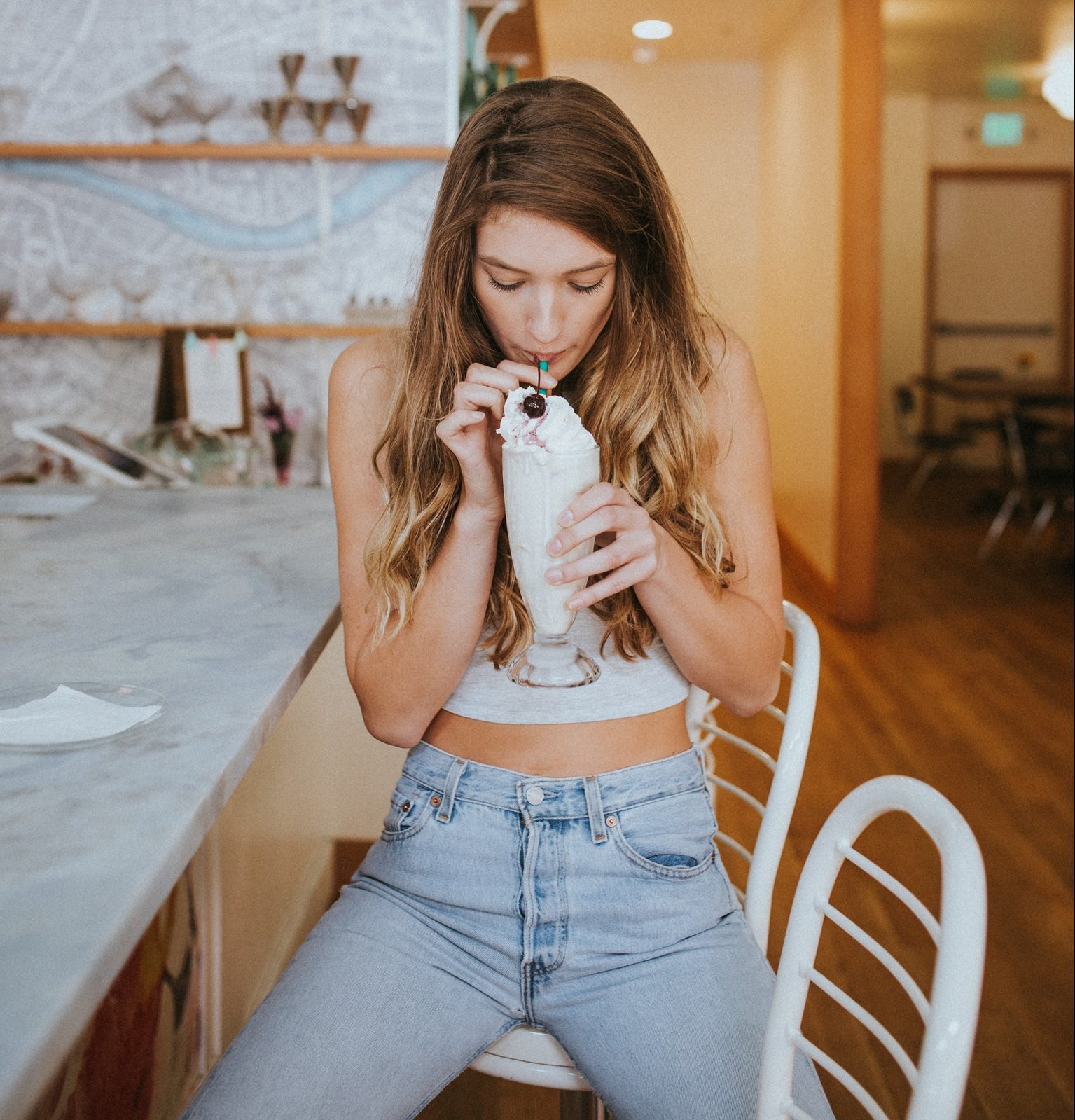 woman sipping a milkshake sitting